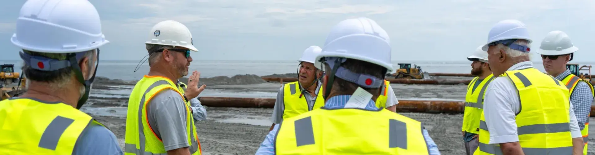 Residents, staff, and committee members meeting on the beach